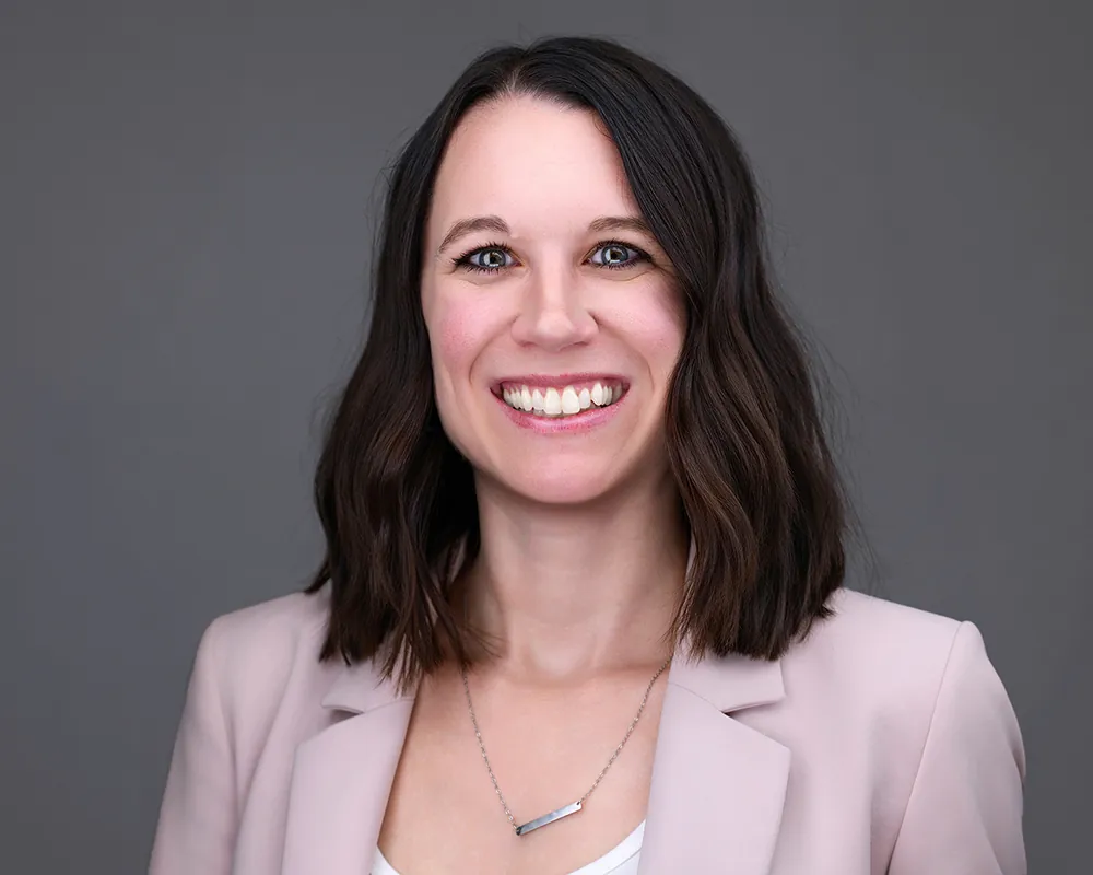 Professional convention headshot of a smiling woman in a pink blazer photographed in Orlando.