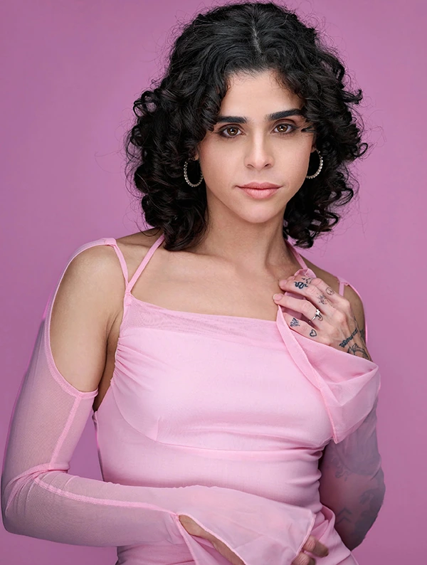Creative actor headshot of a woman in a pink outfit against a coordinating pink studio background.