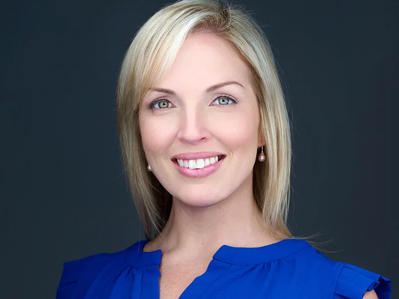 Smiling professional in a blue top, photographed by Headshots Fort Lauderdale