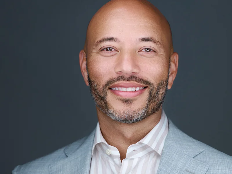 Smiling professional in a light grey blazer