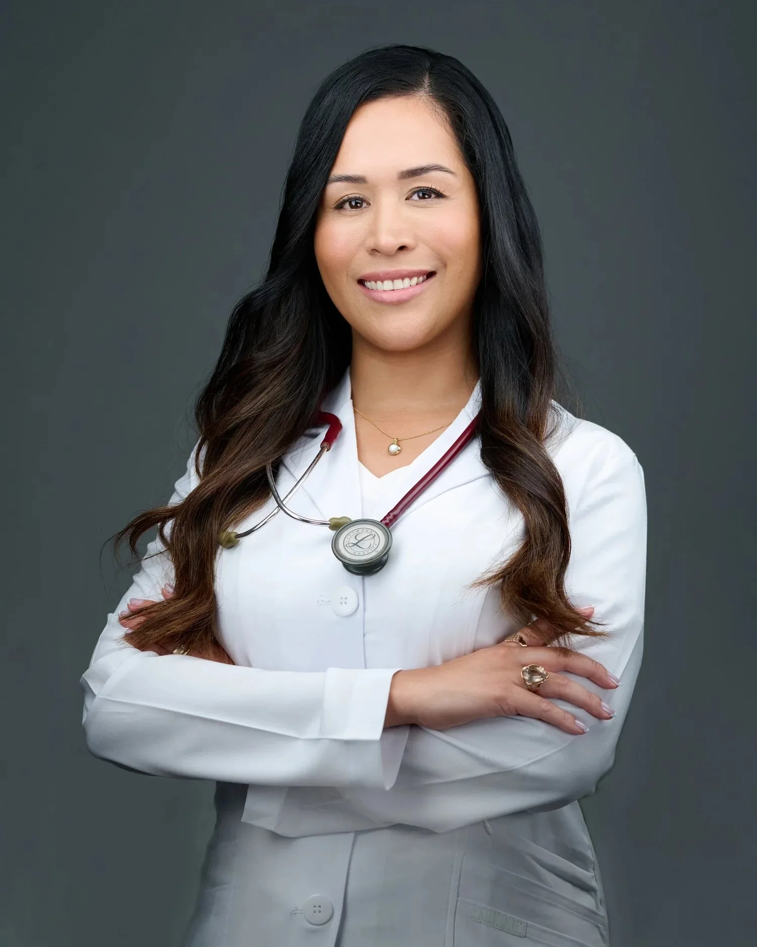 Medical professional in a white coat with a stethoscope, photographed for her practice
