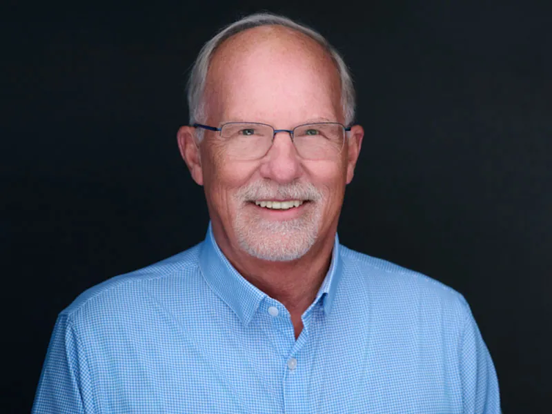 Professional corporate headshot of a smiling Recovery United team member in a blue shirt.