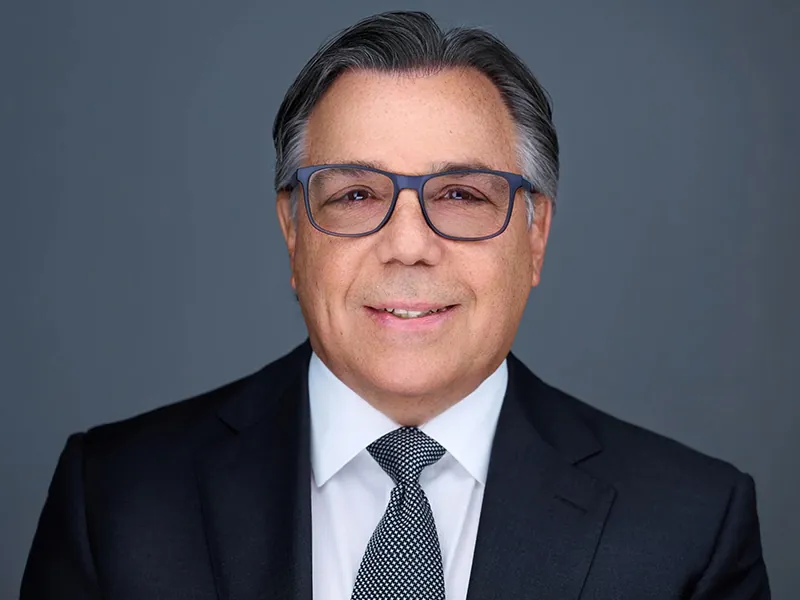 Professional headshot of a Rockefeller Capital executive wearing glasses and a suit.
