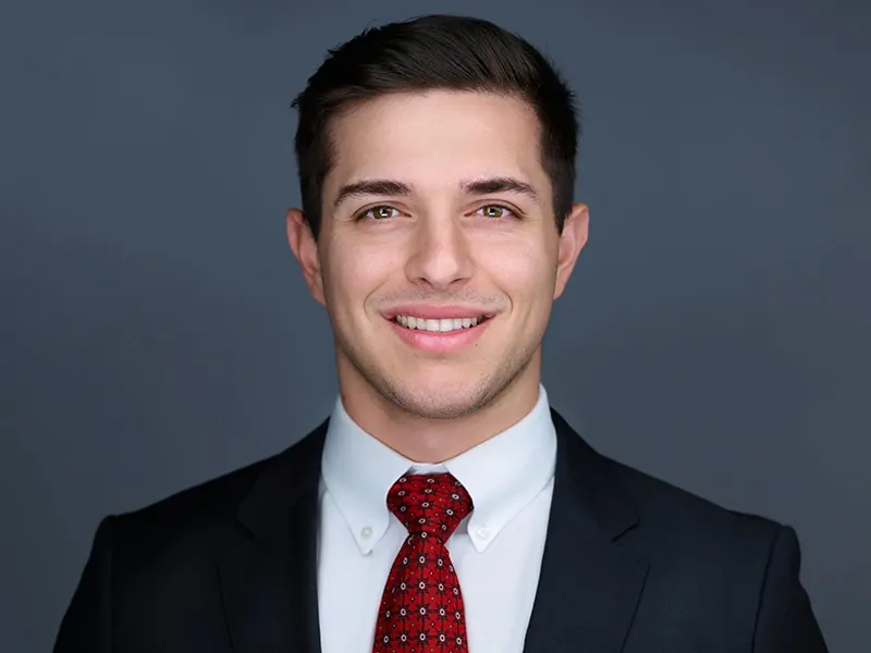 Professional team headshot of a Rockefeller Capital team member in a suit and red tie.